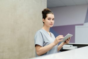 Hôtesse d’accueil en entreprise recevant un visiteur au comptoir d’accueil